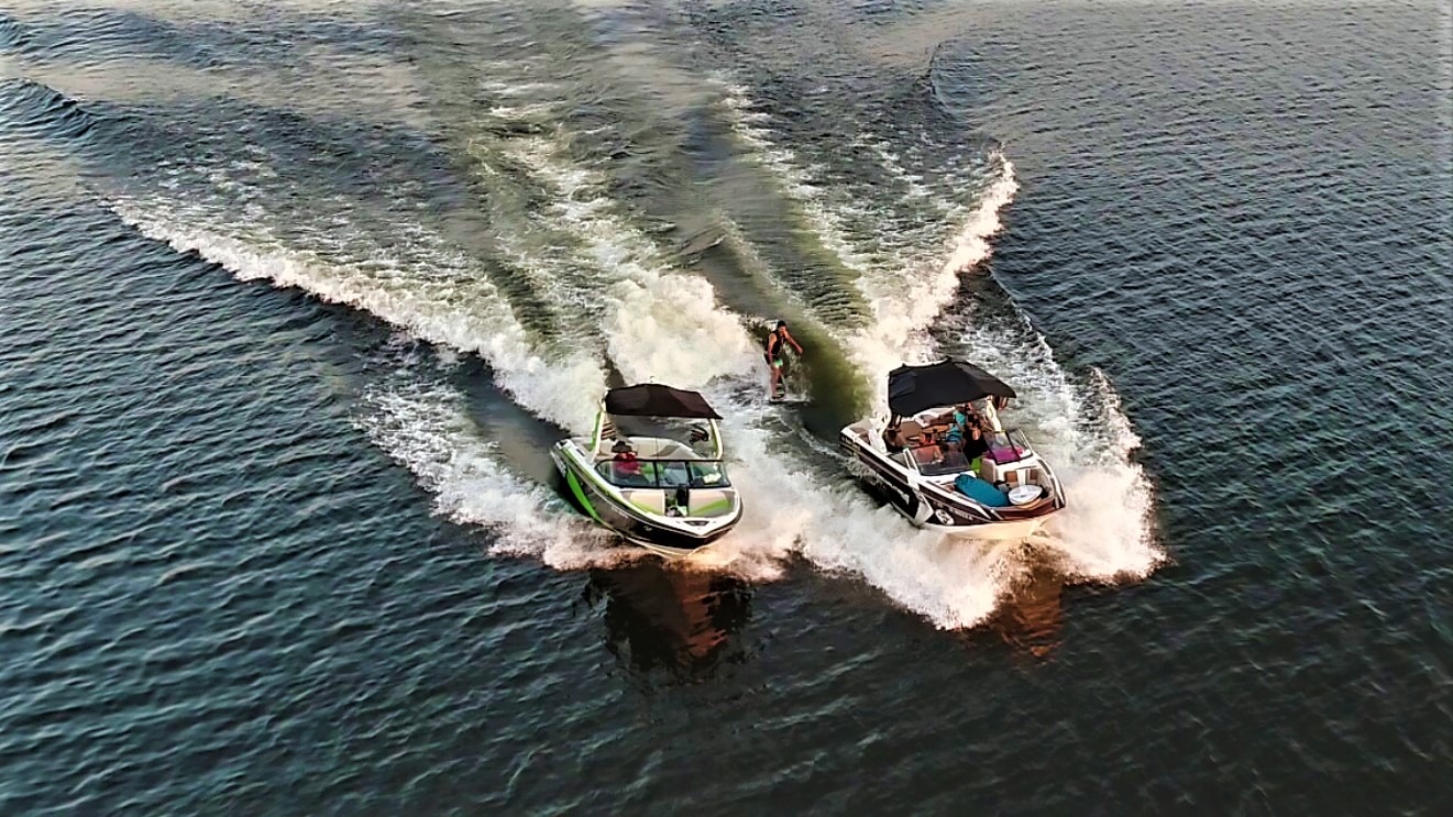 A Wake Surfer Rides the Wave Between Two Speedboat